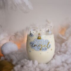 Sheepworld Glas Schutzengel – Moodbild zeigt das Glas, gefüllt mit Milch, auf einer Wolken- und Federndekoration
