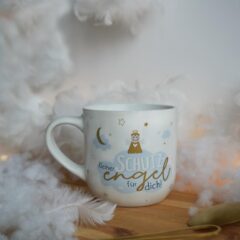 Sheepworld Becher Schutzengel - Moodbild zeigt die Tasse auf einer Wolken- und Federndekoration