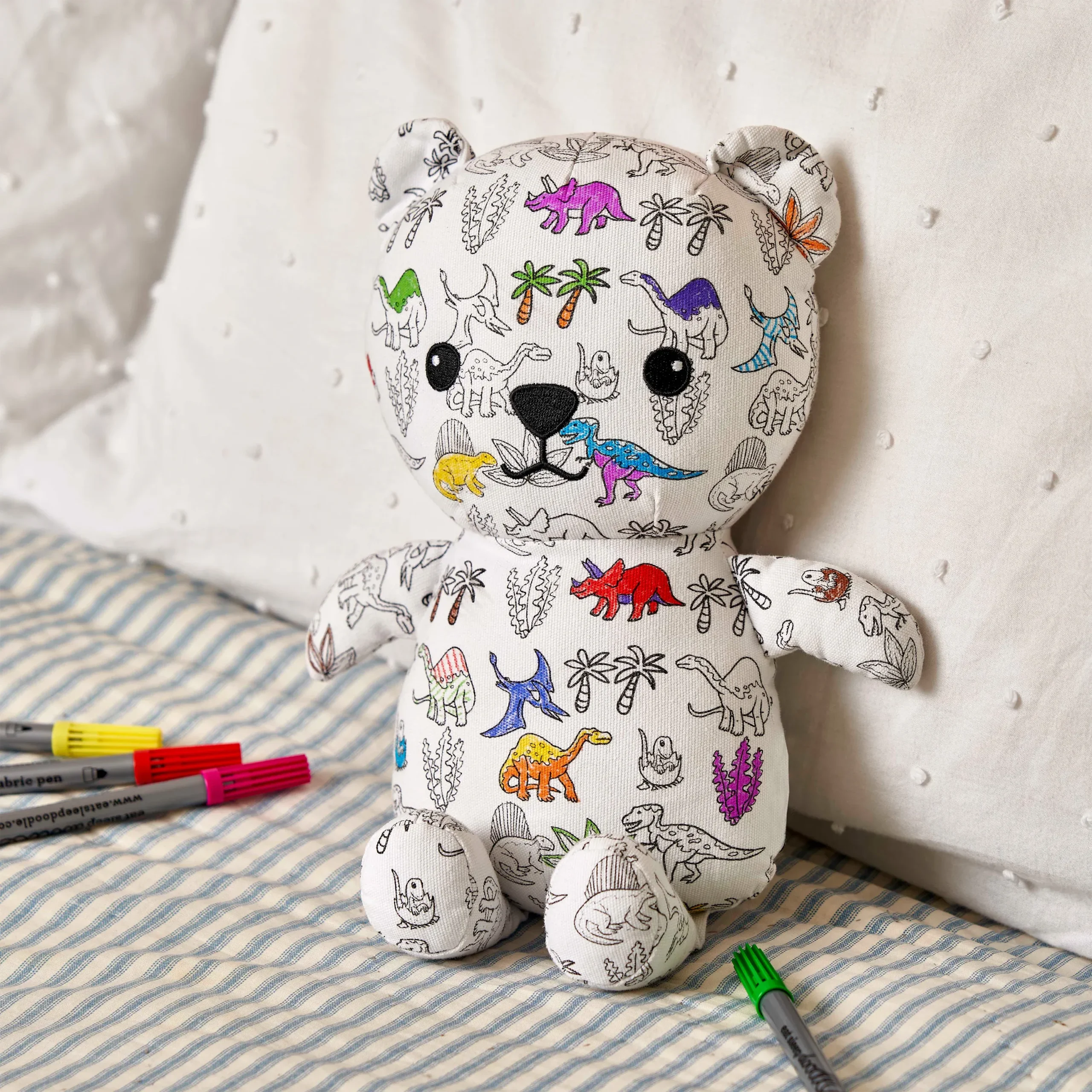 Teddybär Artie "Dinosaurier" zum Ausmalen, Moodbild; zeigt den zum Teil ausgemalten Bär