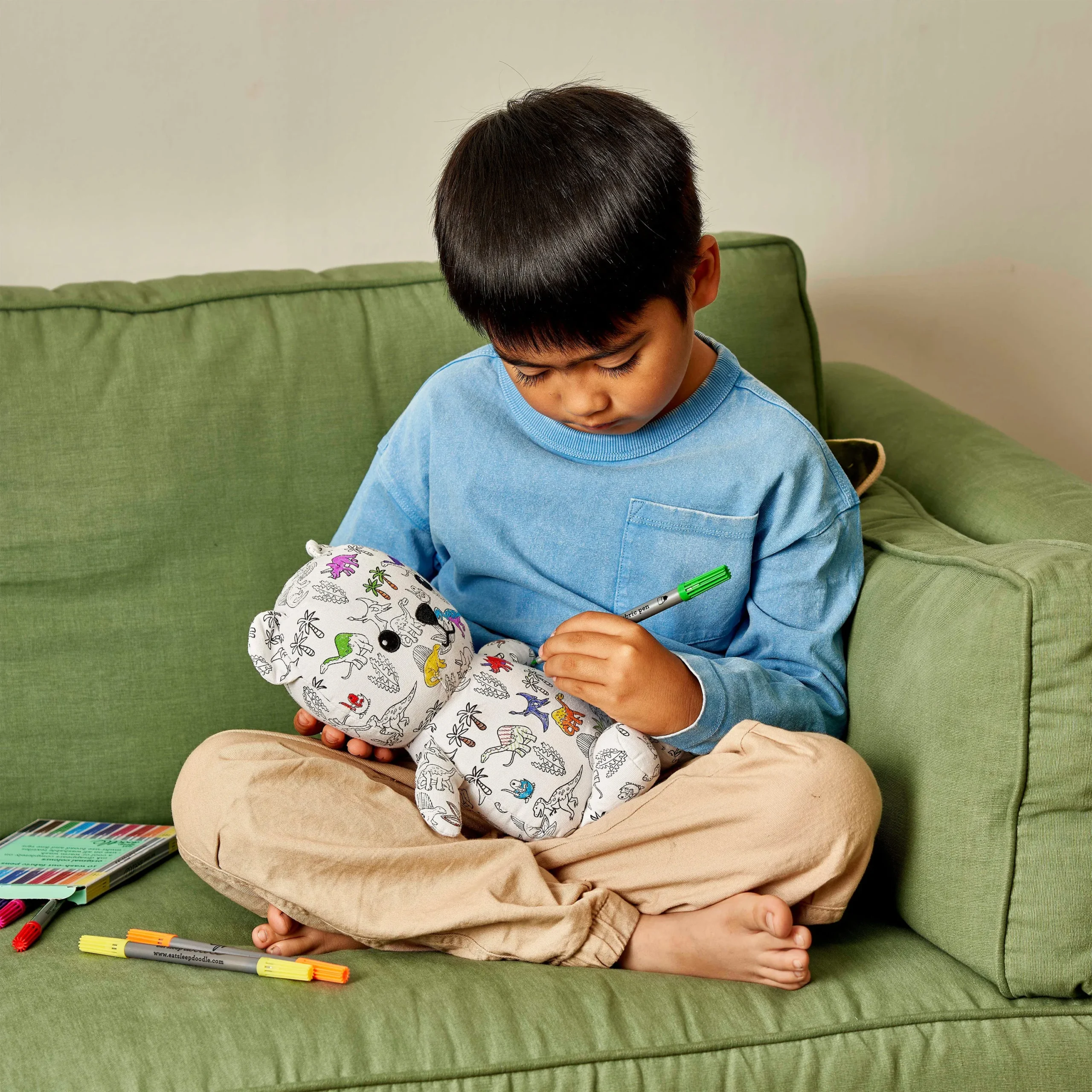 Teddybär Artie "Dinosaurier" zum Ausmalen, Moodbild; zeigt ein Kind beim Ausmalen