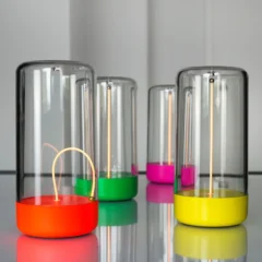 Mehrere Akku-Tischleuchten PULSE by Sompex in verschiedenen Farben auf einer spiegelnden Oberfläche